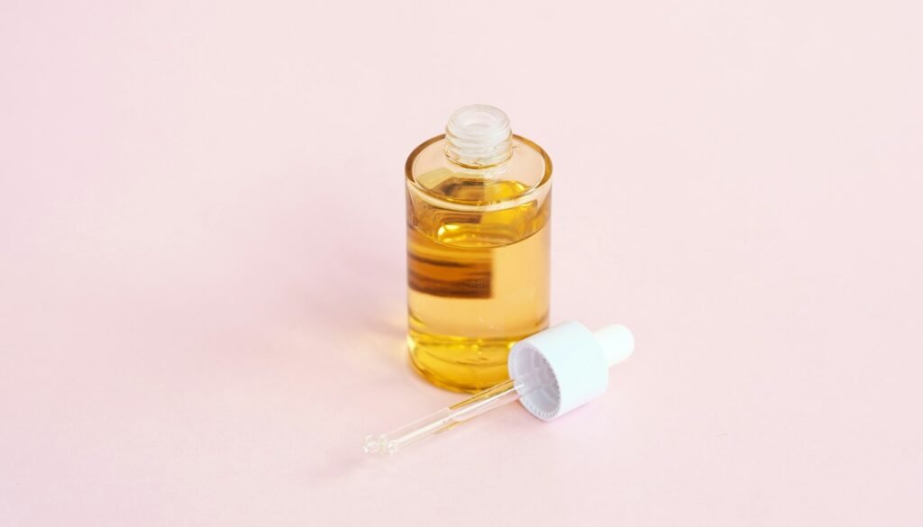 Serum bottle and dropper on a pink surface